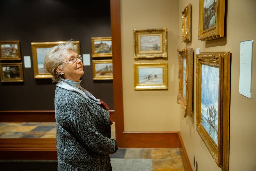Guest admiring paintings at Friends of Alten 2018